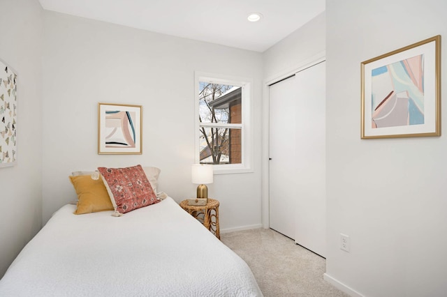 bedroom with light carpet and a closet