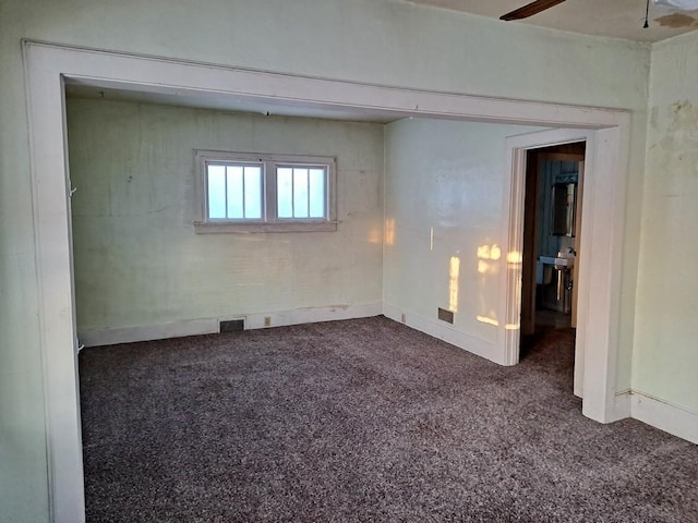 unfurnished room featuring dark carpet