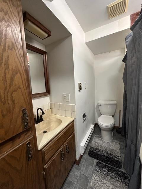 bathroom featuring vanity, toilet, and a baseboard heating unit