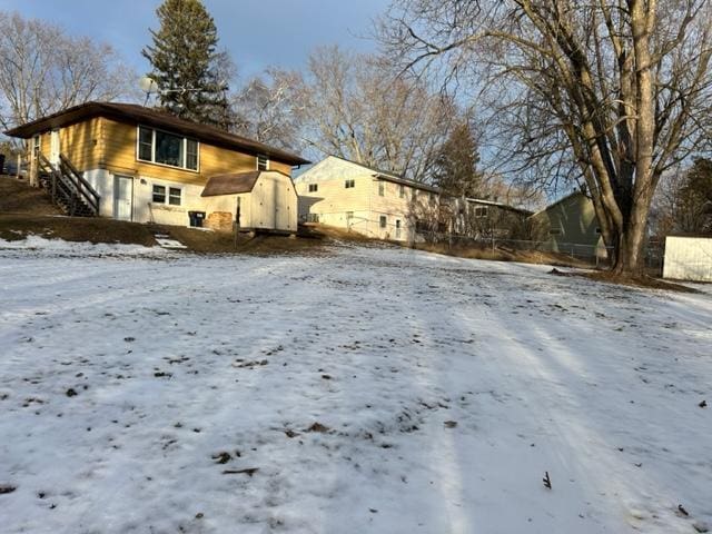 snow covered property featuring a shed