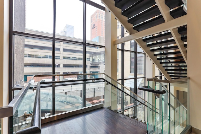 staircase featuring expansive windows and hardwood / wood-style floors