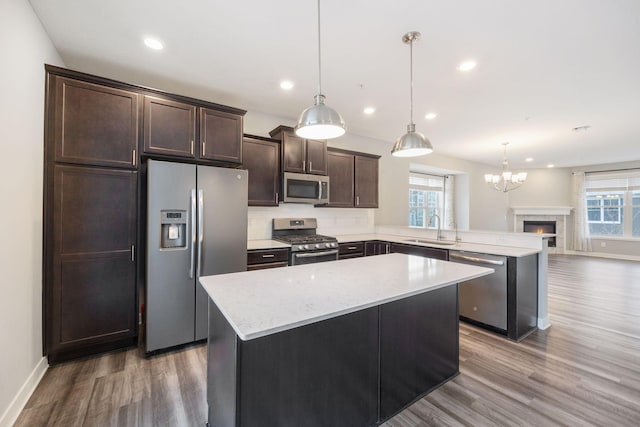 kitchen featuring a wealth of natural light, sink, hanging light fixtures, a center island, and stainless steel appliances