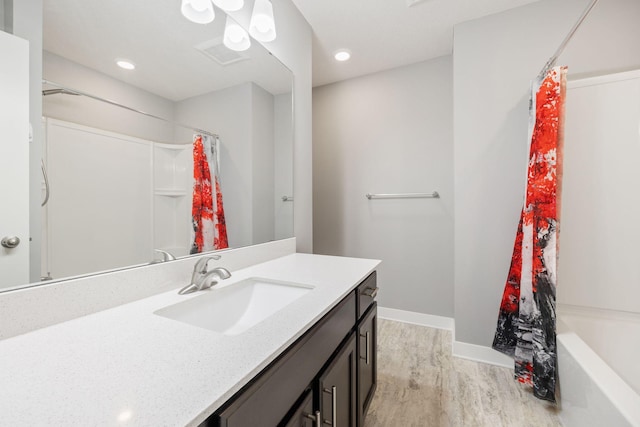 bathroom featuring hardwood / wood-style flooring, vanity, and shower / tub combo