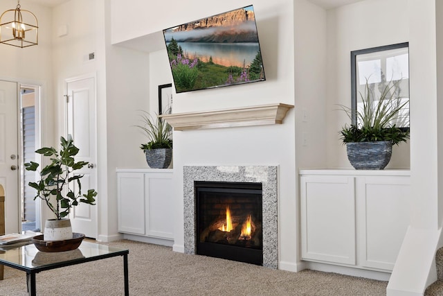 carpeted living room with a chandelier