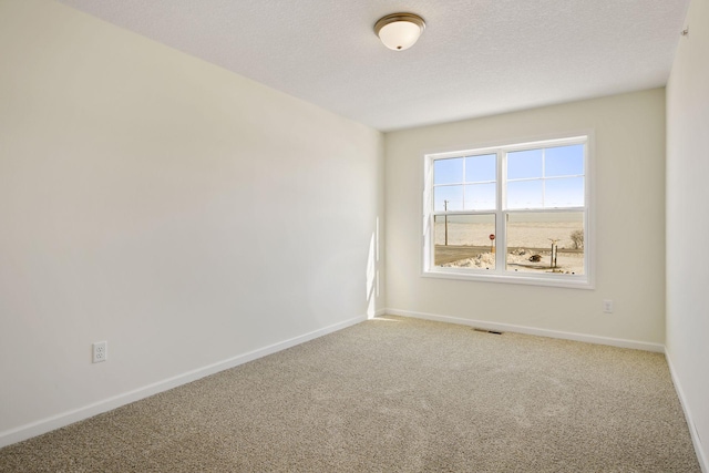 carpeted empty room featuring a textured ceiling