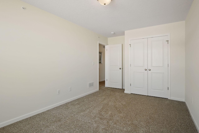 unfurnished bedroom featuring carpet floors, a closet, and a textured ceiling