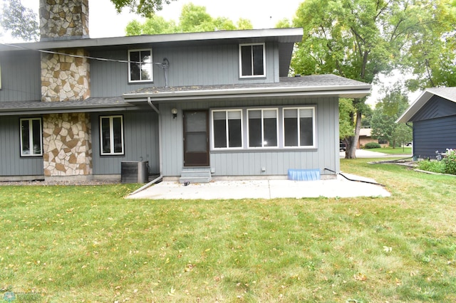 rear view of house with a yard and central AC