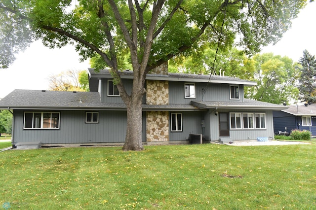 back of property with a yard and central air condition unit