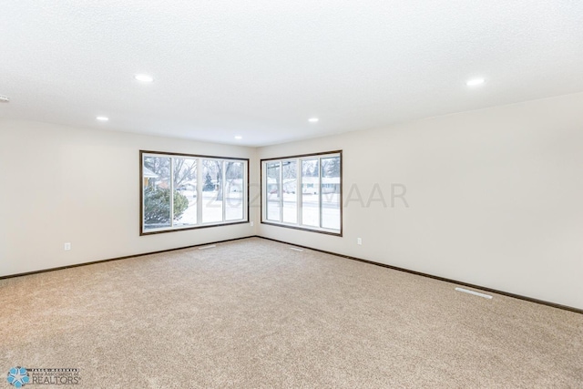 carpeted spare room featuring a textured ceiling