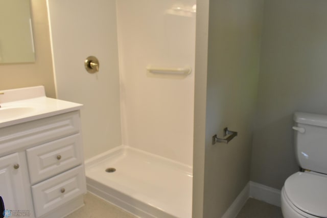 bathroom featuring vanity, toilet, and a shower