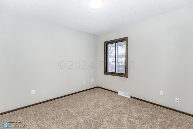 carpeted spare room with a textured ceiling