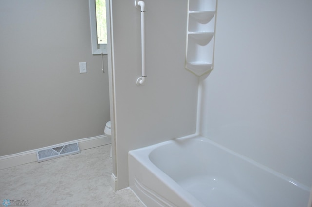 bathroom with a tub and toilet