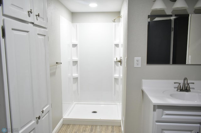 bathroom featuring vanity, hardwood / wood-style floors, and a shower