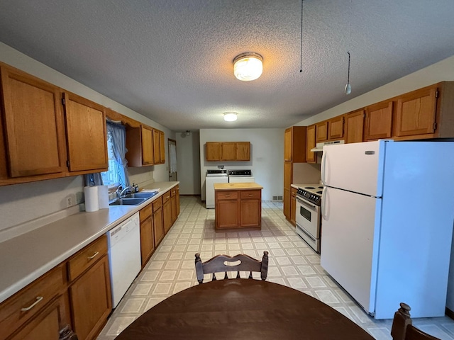 kitchen with white appliances, sink, washing machine and dryer, and a textured ceiling