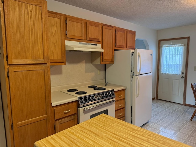 kitchen featuring white appliances and a textured ceiling