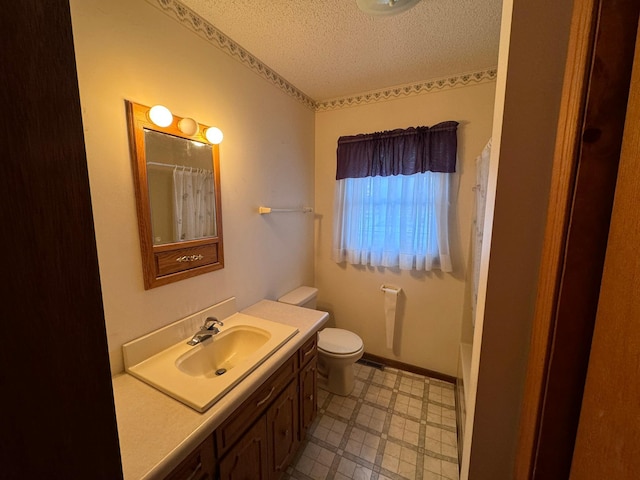 bathroom with a shower with curtain, vanity, a textured ceiling, and toilet