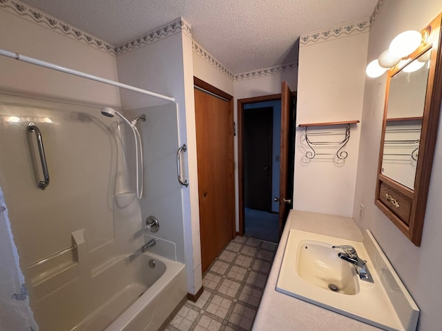 bathroom featuring vanity, bathtub / shower combination, and a textured ceiling