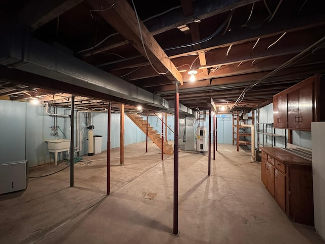 basement featuring electric water heater and sink