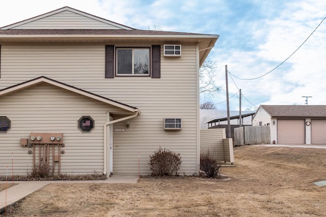 front facade featuring a garage, an outdoor structure, and a front yard