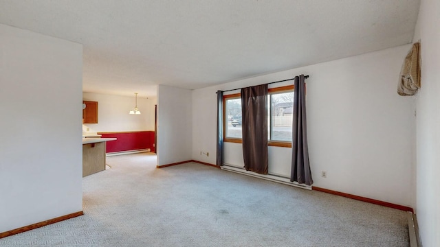 unfurnished room featuring a baseboard heating unit and light colored carpet