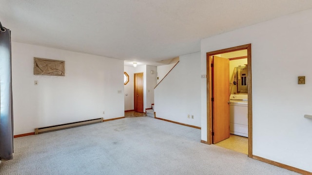 carpeted spare room featuring a baseboard radiator and washer / dryer