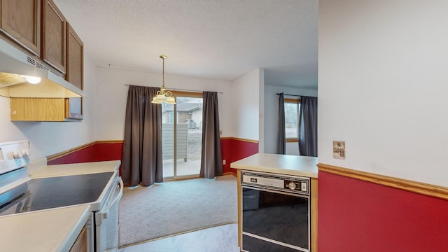 kitchen featuring pendant lighting, light carpet, a textured ceiling, and electric range