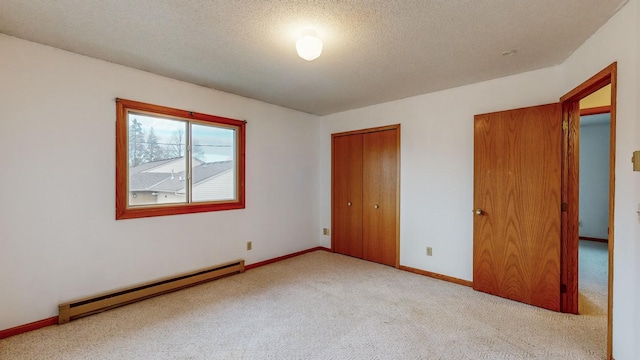 unfurnished bedroom with a baseboard heating unit, light colored carpet, a closet, and a textured ceiling