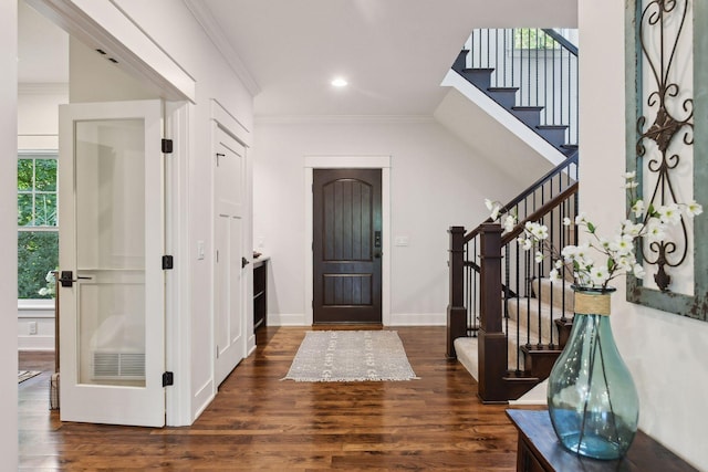 entrance foyer with ornamental molding and dark hardwood / wood-style floors