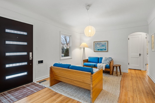 living room featuring ornamental molding and light hardwood / wood-style floors