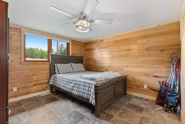 bedroom featuring ceiling fan and wood walls