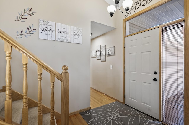 foyer entrance featuring wood-type flooring and a notable chandelier