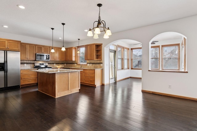 kitchen featuring open shelves, dark wood-style floors, stainless steel appliances, and decorative backsplash