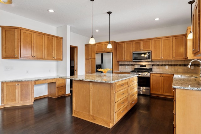 kitchen with dark wood-style flooring, built in desk, decorative backsplash, appliances with stainless steel finishes, and a sink