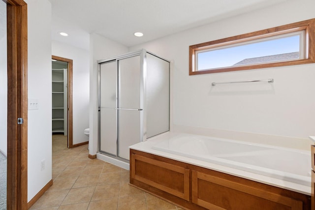 bathroom featuring tile patterned flooring, recessed lighting, a spacious closet, a bath, and a stall shower