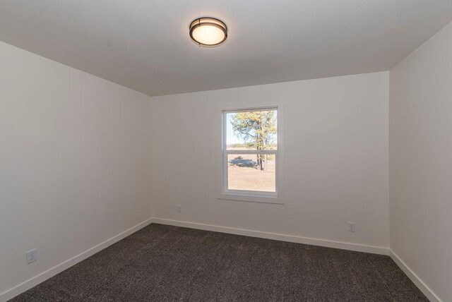 empty room featuring dark carpet