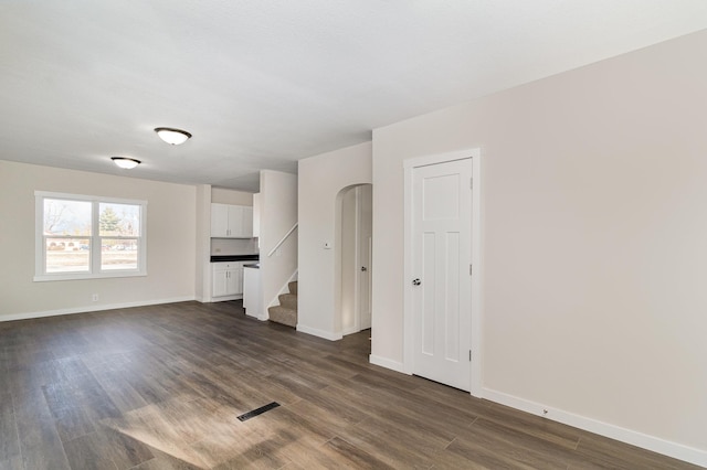 unfurnished living room with dark hardwood / wood-style flooring