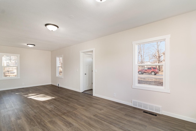 unfurnished room with plenty of natural light and dark hardwood / wood-style floors