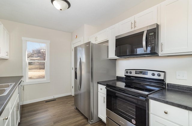 kitchen featuring sink, dark wood-type flooring, white cabinets, and appliances with stainless steel finishes