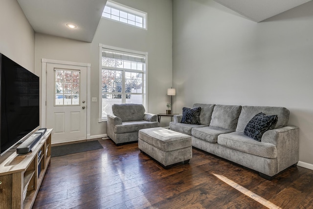 living room with plenty of natural light and dark wood-type flooring