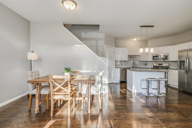 kitchen with pendant lighting, tasteful backsplash, white cabinetry, a center island, and stainless steel appliances