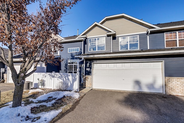 view of front of property with a garage and central AC unit