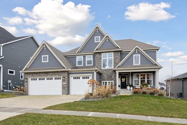 craftsman house with a garage, central AC, and a front yard