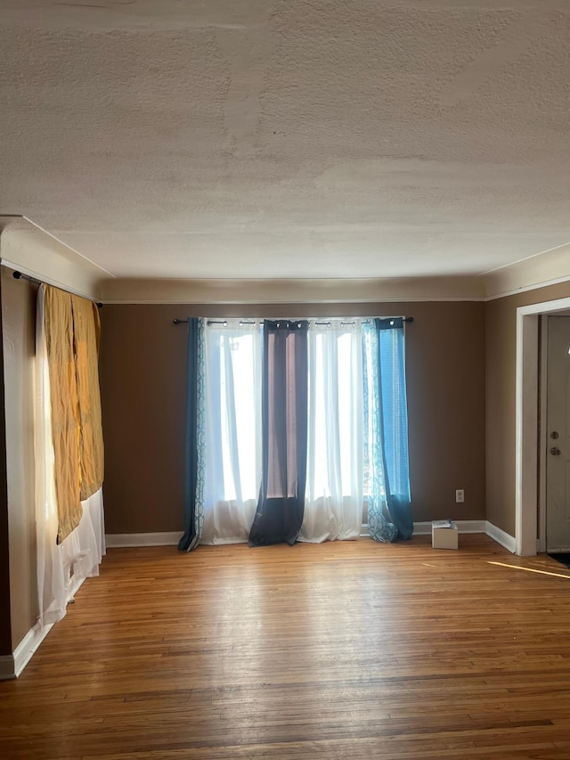 empty room featuring wood-type flooring and a textured ceiling