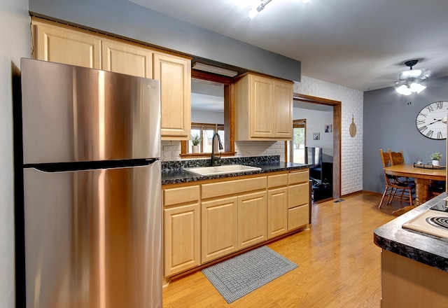 kitchen featuring light hardwood / wood-style flooring, sink, stainless steel fridge, and ceiling fan