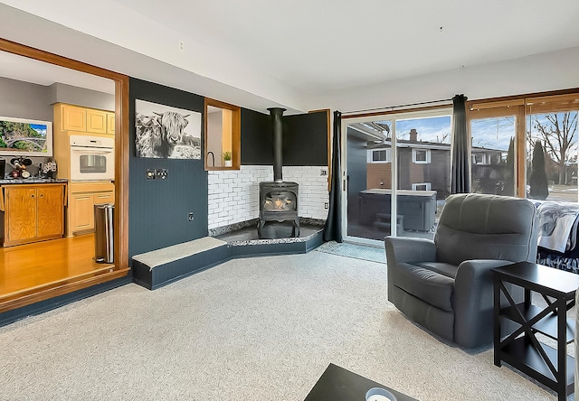 carpeted living room featuring a wood stove