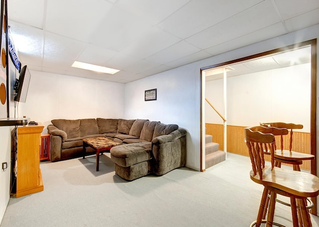 carpeted living room with a paneled ceiling