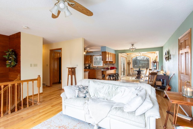 living room featuring ceiling fan and light hardwood / wood-style flooring