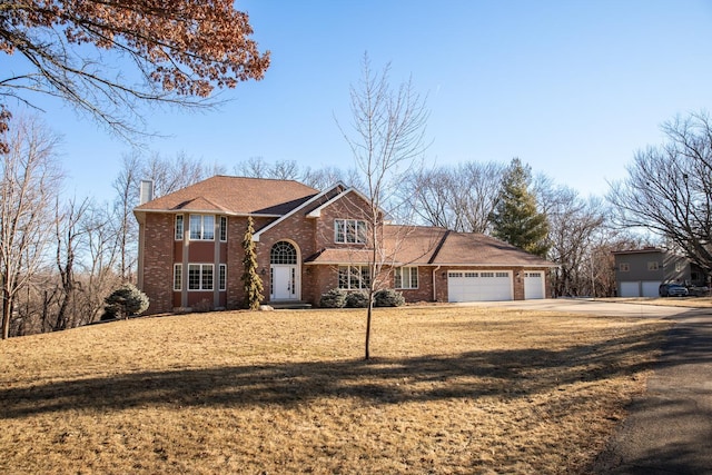 front facade featuring a garage and a front yard