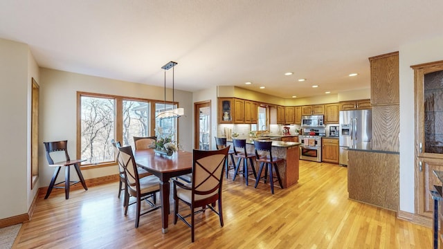 dining area with sink and light wood-type flooring