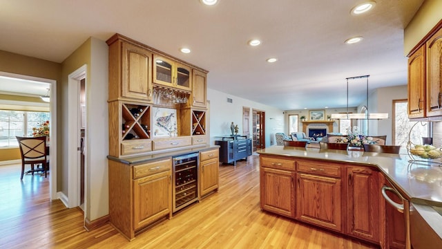 kitchen featuring pendant lighting, light hardwood / wood-style flooring, and wine cooler